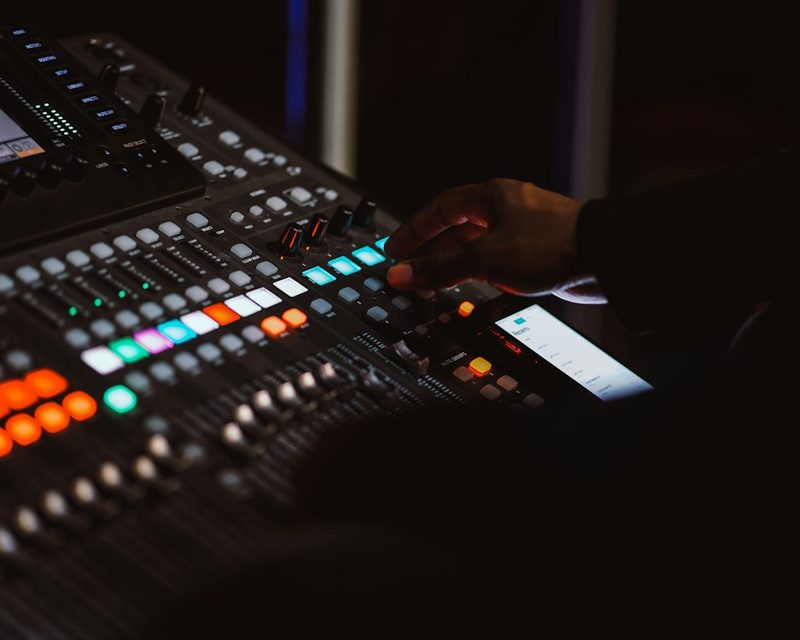 Sound engineer operating a digital audio mixing console
