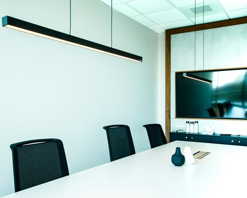 Modern boardroom with a wall-mounted display and integrated meeting room technology